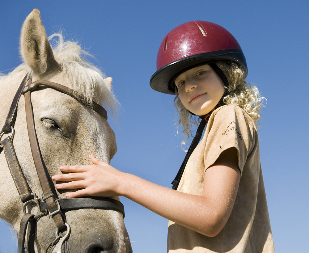 une jeune fille caresse un cheval